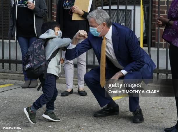 New York City Mayor Bill de Blasio does a social distancing elbow bump with four-year old Oliver as he welcomes students to Pre-K at Mosaic Pre-K...