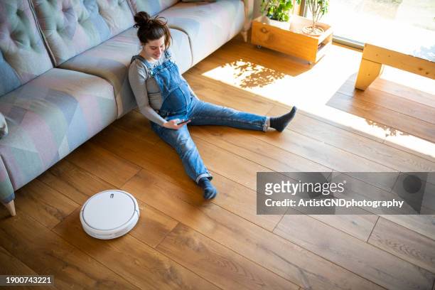 pregnancy is easy with smart home and vacuum cleaner at home. - vacuum cleaner woman stockfoto's en -beelden