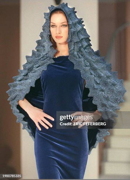 Un mannequin du couturier Pierre Cardin présente une robe en soie bleu avec une cape fantaisie, le 17 mars à Paris, dans le cadre des collections de...