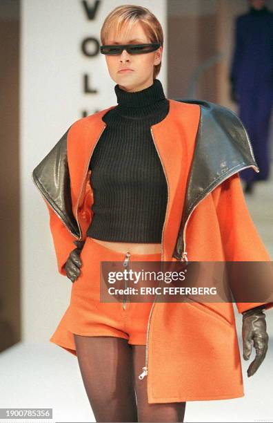 Un mannequin du couturier Pierre Cardin présente, le 17 mars à Paris, un ensemble mini-jupe orange avec une cape à doublure en cuir dans le cadre des...