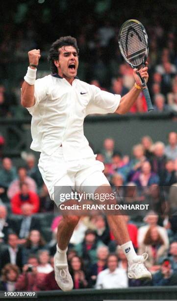 Frenchman Cedric Pioline shows his joy as he jumps higher than the net 04 July at the Wimbledon Tennis Championships after beating German Michael...