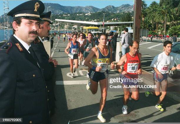 Des douaniers italiens regardent passer, le 23 novembre près de la frontière franco-italienne, les coureurs du premier marathon international de...