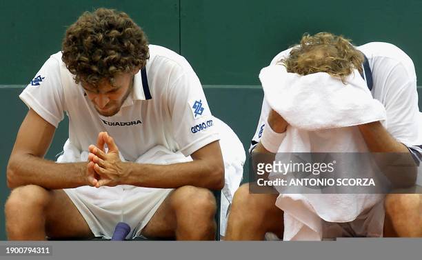 Brazilian tennis player Gustavo Kuerten concentrates next to his teammate Jaime Oncins during the last set of a Davis Cup match against Australian...