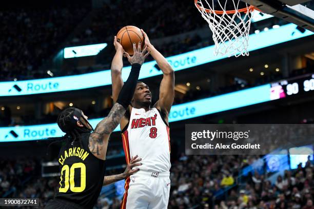 Jamal Cain of the Miami Heat dunks over Jordan Clarkson of the Utah Jazz during the second half of a game at Delta Center on December 30, 2023 in...