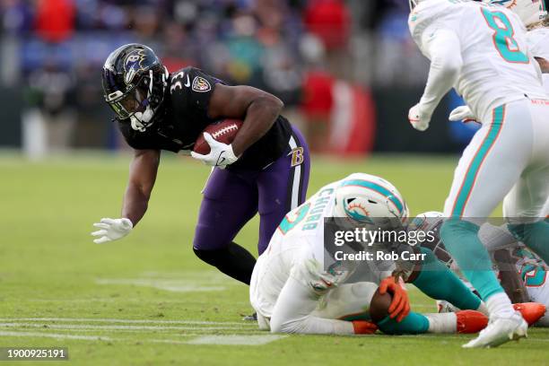 Linebacker Bradley Chubb of the Miami Dolphins reacts after getting injured as running back Melvin Gordon III of the Baltimore Ravens carries the...