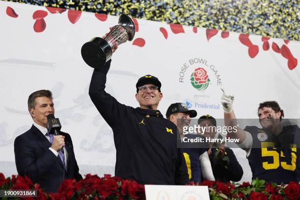 Head coach Jim Harbaugh of the Michigan Wolverines celebrates with The Leishman Trophy after beating the Alabama Crimson Tide 27-20 in overtime to...