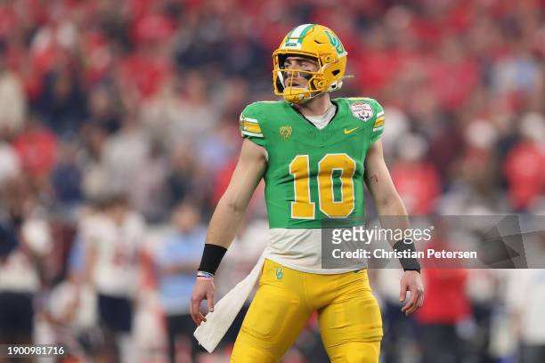 Quarterback Bo Nix of the Oregon Ducks walks off the field during the first half of the Fiesta Bowl against the Liberty Flames at State Farm Stadium...