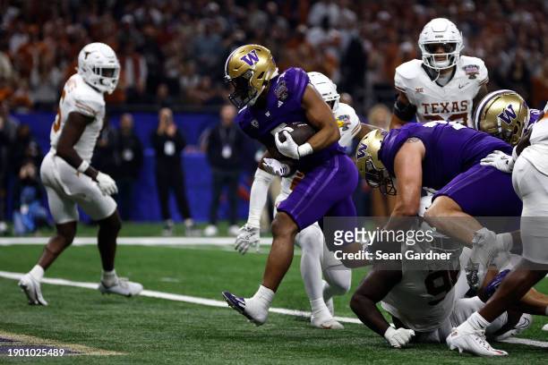 Dillon Johnson of the Washington Huskies rushes for a touchdown during the second quarter against the Texas Longhorns during the CFP Semifinal...