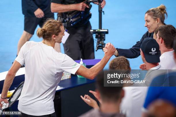 Germany's Alexander Zverev shakes hands with teammate Angelique Kerber after his victory against Greece's Stefanos Tsitsipas during their men's...