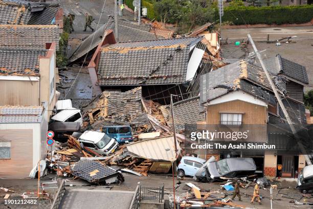 In this aerial image, collapsed houses and cars are seen at Horyumachi district after tsunami triggered by multiple strong earthquakes the previous...