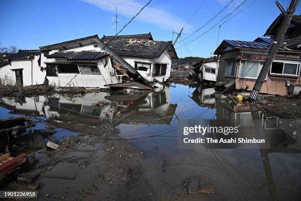 Collapsed houses are seen while seawater remains at Horyumachi district after tsunami triggered by multiple strong earthquakes the previous day on...