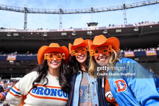 Denver Broncos fans dressed with colorful costumes and New Years Eve flair cheer as they watch a game between the Denver Broncos and the Los Angeles...