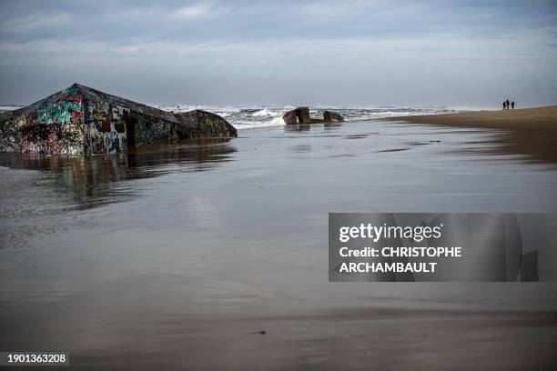 This photograph taken on January 4 shows a concrete bunkers from World War II decorated with graffiti on the beach along the Atlantic Ocean in...