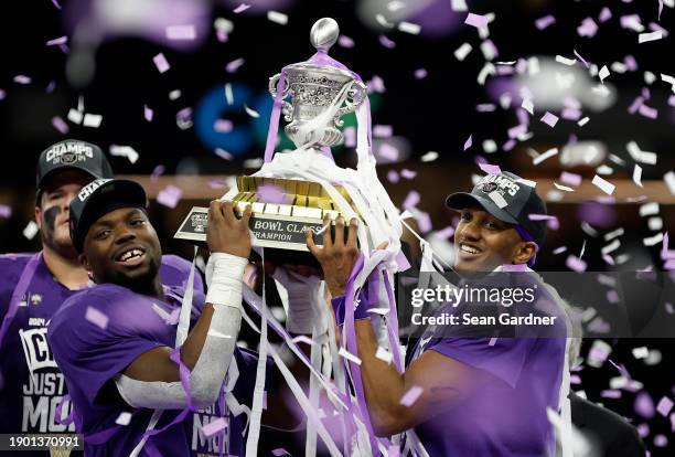 Michael Penix Jr. #9 of the Washington Huskies and Edefuan Ulofoshio celebrate with the trophy after a 37-31 victory against the Texas Longhorns in...