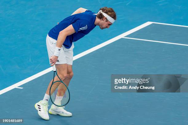 Stefanos Tsitsipas of Team Greece sustains a back injury as he competes with Maria Sakkari in the Group B doubles match against Tomas Barrios Vera...
