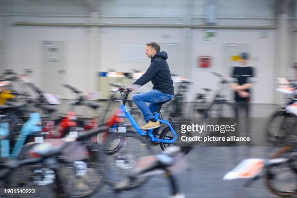 January 2024, Saxony-Anhalt, Magdeburg: A man tries out a pedelec at the "Tourisma und Caravaning Magdeburg" trade fair stand. Over 120 exhibitors...