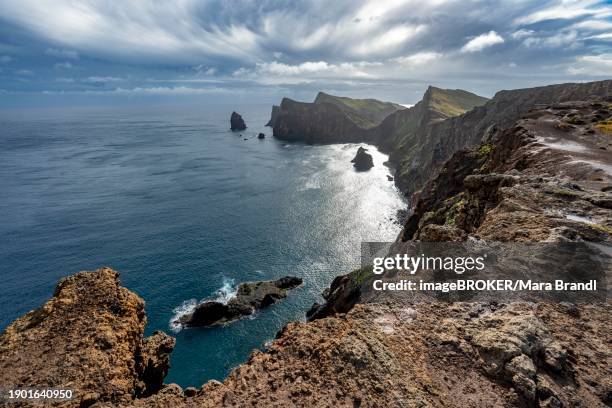 red cliffs and rocks in the sea, coastal landscape with dramatic sky, ponta de sao lourenco, volcanic peninsula sao lourenco, ponta de san lorenzo, madeira, portugal, europe - madeira volcano stock pictures, royalty-free photos & images