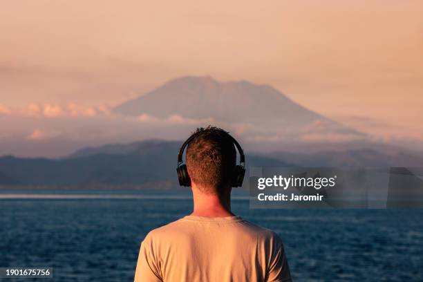 rear view of man with headphones - personal stereo photos et images de collection