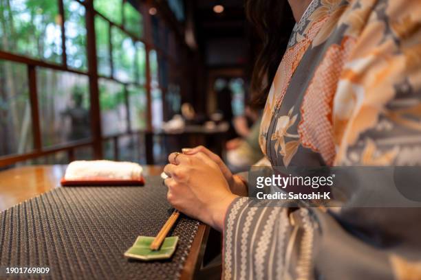 close-up of woman in kimono / hakama waiting for lunch in traditional japanese restaurant - chawanmushi stock pictures, royalty-free photos & images