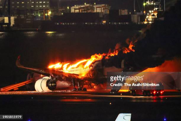 Fire fighting vehicle attempts to extinguish fire of Japan Airlines 516 plane at Haneda Airport on January 2, 2024 in Tokyo, Japan. The airplane...