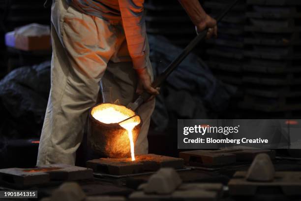 a worker pours molten iron into a mold - glowing hot steel stock pictures, royalty-free photos & images