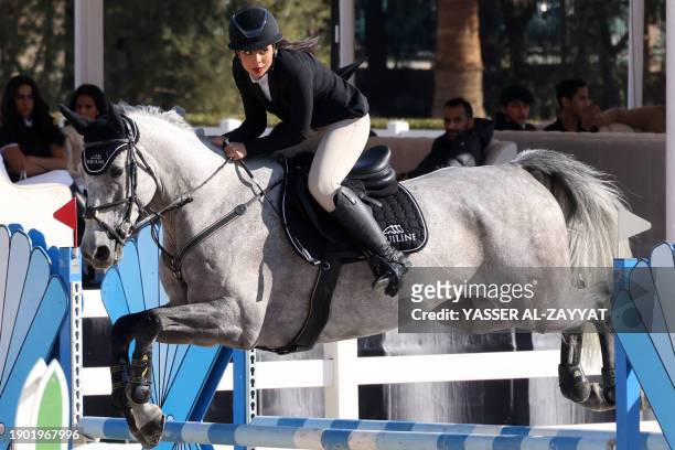 Remas al-Kharafi rides Harlem De La Cense over a hurdle during the 3rd Jumping event at the Hunting and Equestrian Club in Kuwait City on January 5,...
