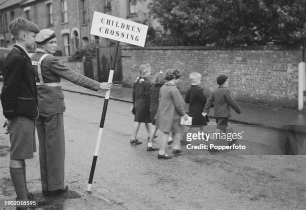 Under the watchful eye of School Safety Patrol Leader David Kemp, a group of school children cross a road outside a school in the city of Norwich in...