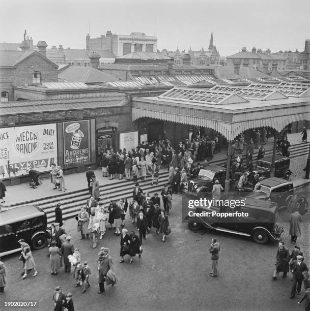 Crowds of summer visitors and day-trippers pass waiting cars as they leave Southend Central railway station in the seaside resort town of...