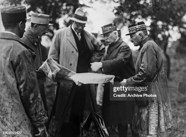 French politician Andre Maginot , Minister of War, and French military officer General Philippe Petain with French officers examining charts of...