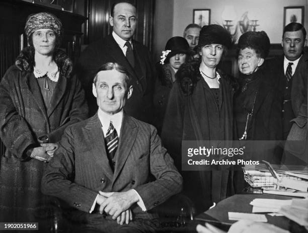 American politician William Gibbs McAdoo, United States Senator from California, seated before a group of people, including his wife, American writer...