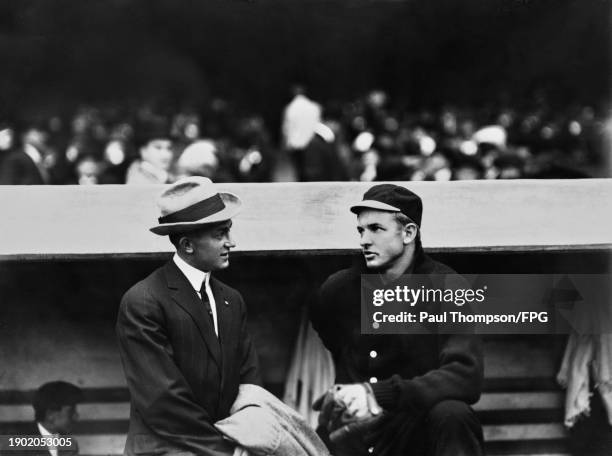 American baseball player Ty Cobb in conversation with American baseball player Christy Mathewson in the dugout ahead of the third game of the 1911...