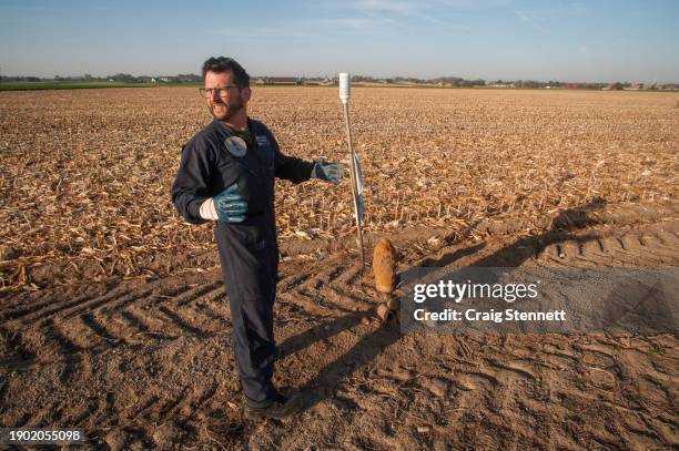 1st Sergeant Major Gino Lambrecht from Belgium bomb clearance team DOVO-SEDEE standing next to a 60- pounder British shell with accompanying 13 & 18...