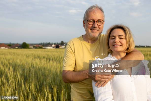mature happy man hugging woman during sunset - may december romance stock pictures, royalty-free photos & images