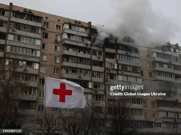 Flag of the Red Cross is seen in front of a residential building damaged by Russian shelling on January 2, 2024 in Kyiv, Ukraine. As a result of the...