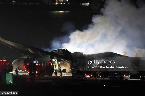 Smoke rises from Japan Airlines 516 plane after fire extinguishing oepration at Haneda Airport on January 2, 2024 in Tokyo, Japan. The airplane...