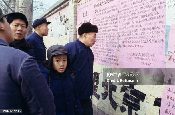 People reading wall posters along a main street in Beijing, China, December 30th 1978.