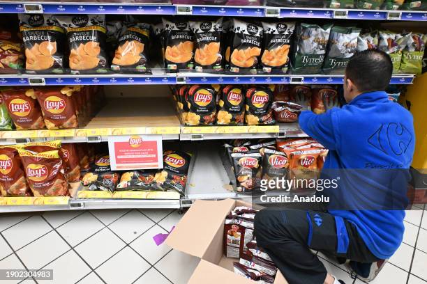 Grocery store clerk removes PepsiCo products from the shelves after the French multinational retail and wholesale company Carrefour has stopped...
