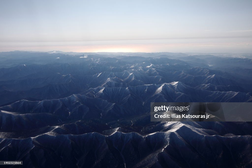 View of snow covered mountain range from airplane