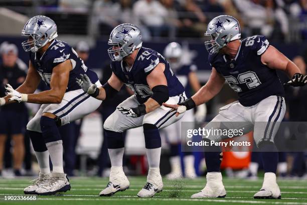 Terence Steele of the Dallas Cowboys, Zack Martin, and Tyler Biadasz drop back to block during an NFL football game against the Detroit Lions at AT&T...