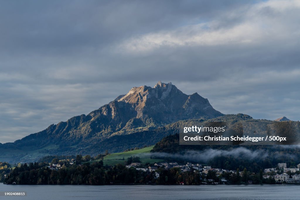 Scenic view of lake by mountains against sky
