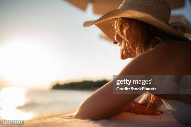 woman whit sun hat lying at the beach - sun hat stock pictures, royalty-free photos & images