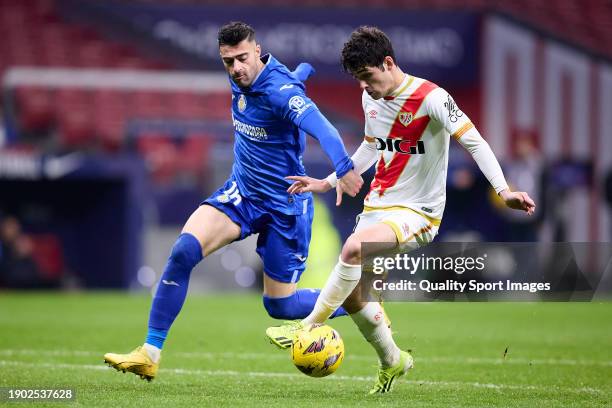 Sergio Camello of Rayo Vallecano competes for the ball with Diego Rico of Getafe CF during the LaLiga EA Sports match between Getafe CF and Rayo...