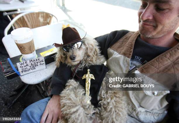 Blondie holds an Oscar statue, as her owner Robin "Doc" Wilson waits 24 February 2007 for tourists' tips in a bar at the entrance of the Kodak...