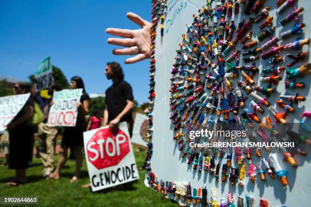 An activists holds a sign made with little people during a rally in front of the White House 20 June, 2006 in Washington, DC. In an effort to...