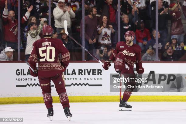 Jason Zucker of the Arizona Coyotes celebrates with Sean Durzi after scoring a goal against the Colorado Avalanche during the third period of the NHL...