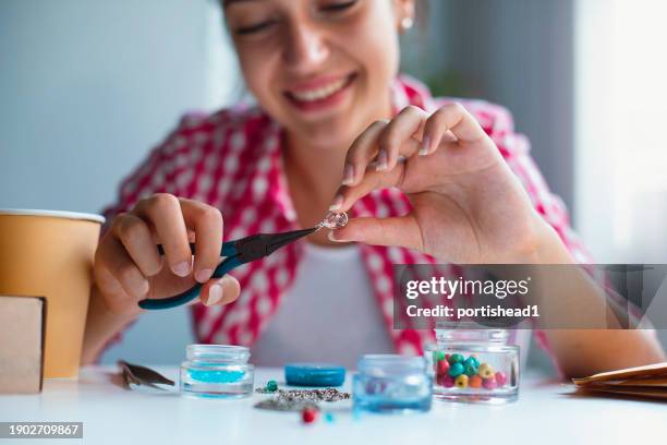 happy smiling teenage girl making handmade jewelry - homemade stock pictures, royalty-free photos & images