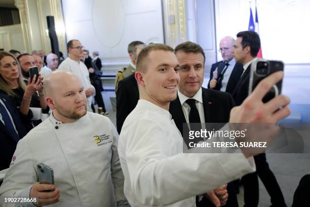 Members of the French Bakery and Pastry Federation take a selfie with French President Emmanuel Macron during the traditional Epiphany cake ceremony...
