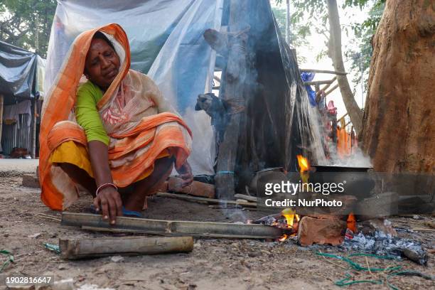 Woman is cooking food on a wood fire stove at a transit camp of the Gangasagar fair in Kolkata, India, on January 5, 2024.