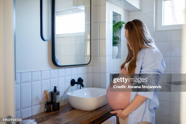 pregnant woman and morning routine in the bathroom - stretch mark stock pictures, royalty-free photos & images
