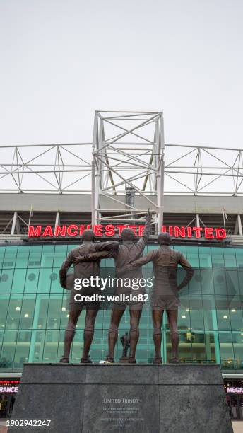 united trinity and sir matt busby statues at old trafford - manchester city premier league stock pictures, royalty-free photos & images